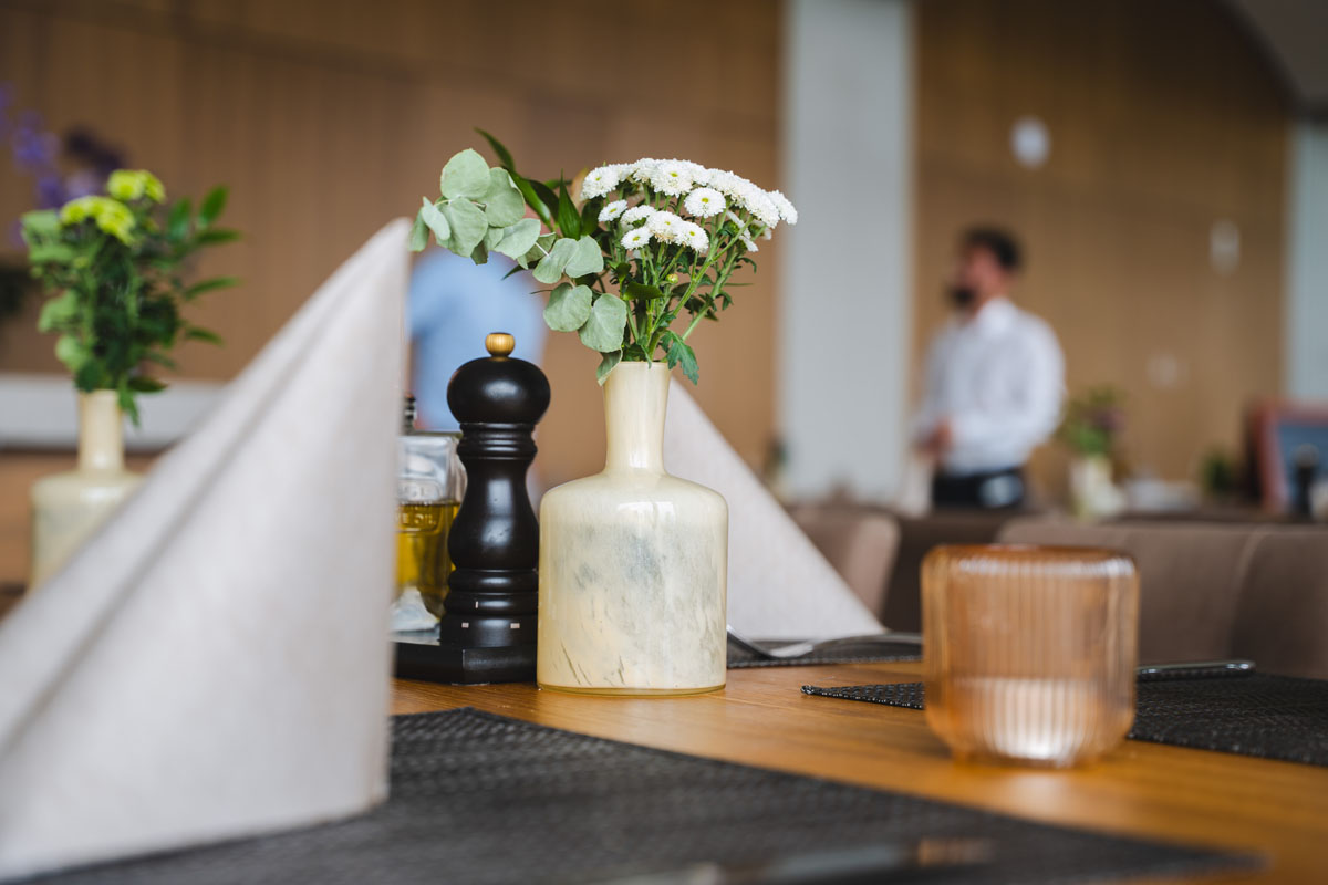 Eingedeckter Tisch mit Kerze und Blumenvase